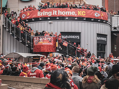 A group of people standing around a "Bring it home, KC" banner.