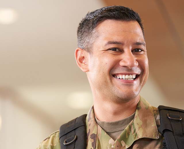 A person in a military uniform smiling.