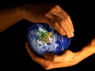 A person's hands holding a small globe.