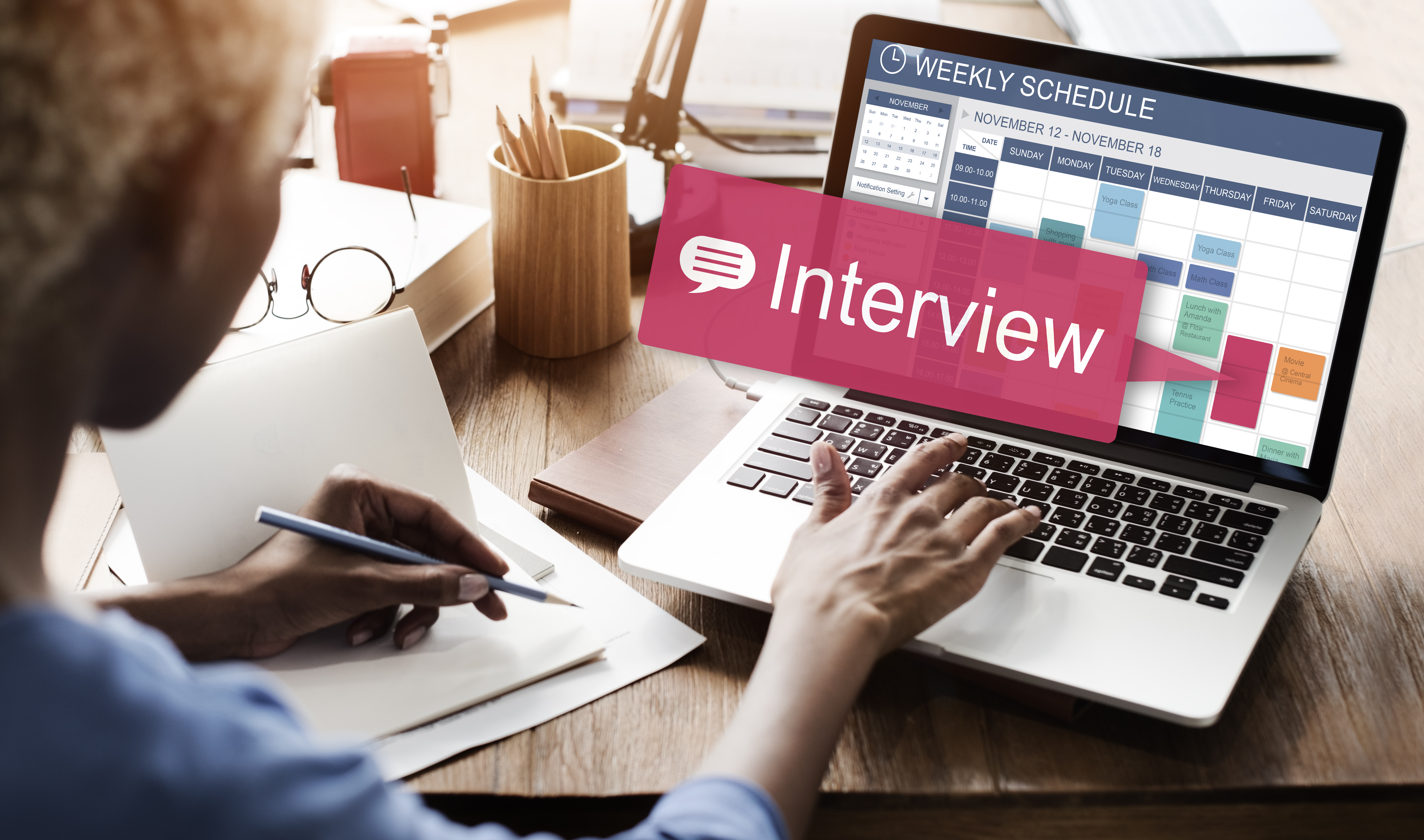 A woman at a laptop with the word interview showing on her schedule.