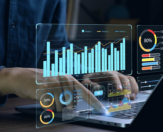 An image of graphs overlaid over someone typing on a laptop.